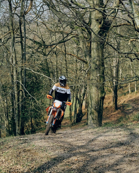 Dan riding in the forest wearing our BSMC Wing Race Jersey - Gold