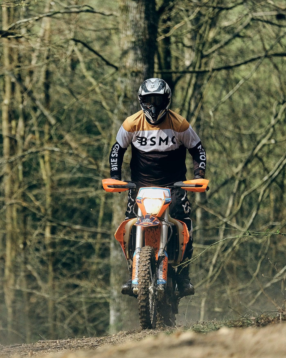 Dan riding in the forest wearing our BSMC Wing Race Jersey - Gold
