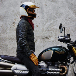 Model wearing our BSMC x Hedon Club Classic Helmet DOT sitting on his Triumph