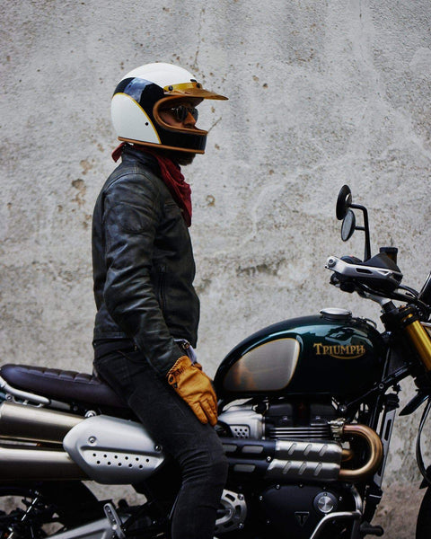 Model wearing our BSMC x Hedon Club Classic Motorcycle Helmet DOT sitting on his Triumph