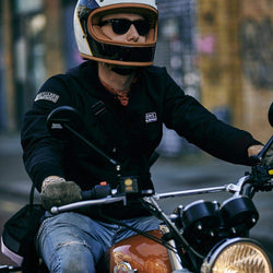 Kane wearing our BSMC x Royal Enfield Bomber Jacket - Black while riding a Royal Enfield 