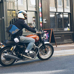 Kane wearing our BSMC x Royal Enfield Bomber Jacket - Black, riding a Royal Enfield