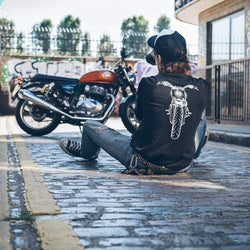 Kane taking a photo of a Royal Enfield while wearing our BSMC x Royal Enfield Headlight LS T Shirt - Black