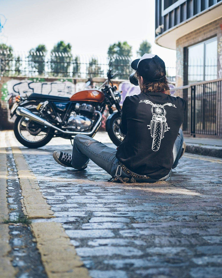 Kane taking a photo of a Royal Enfield while wearing our BSMC x Royal Enfield Headlight LS T Shirt - Black