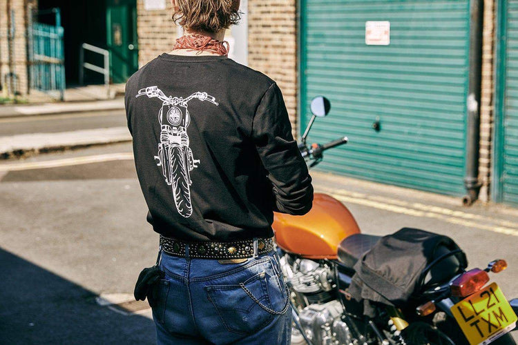 Kane wearing our BSMC x Royal Enfield Headlight LS T Shirt - Black next to a Royal Enfield