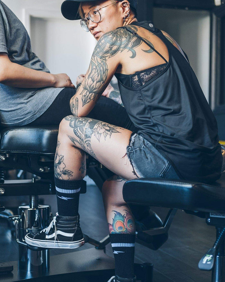 Carrie tattooing wearing our BSMC x Royal Enfield Lightning Socks