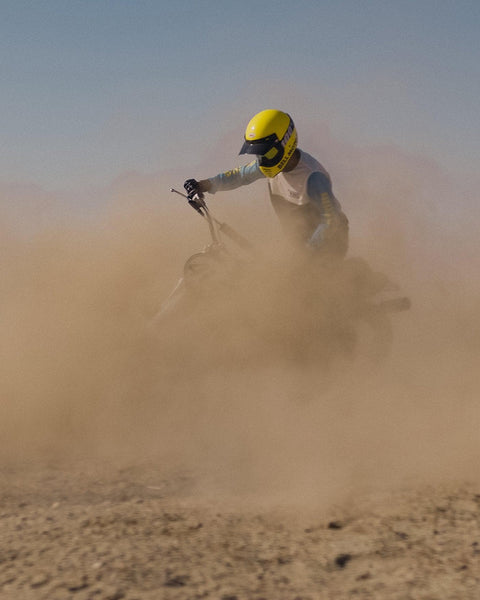 Rider kicking up dust on dirt bike wearing our BSMC XT Motorcycle Race Jersey - BLUE/WHITE/BLACK