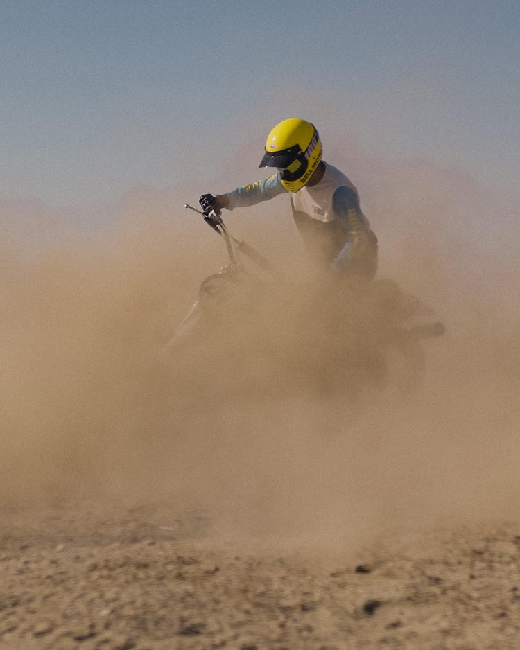 Rider kicking up dust on dirt bike wearing our BSMC XT Race Jersey - BLUE/WHITE/BLACK
